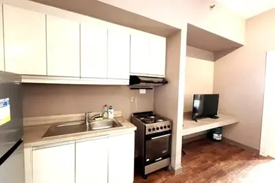 a small kitchen with a sink and a stove at 1BR with Balcony KL Tower, Greenbelt near AIM in Manila
