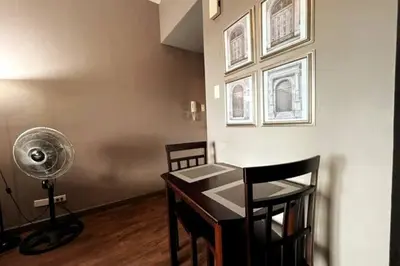 a room with a desk with a fan and chairs at 1BR with Balcony KL Tower, Greenbelt near AIM in Manila