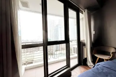 a bedroom with a large window with a view of a city at 1BR with Balcony KL Tower, Greenbelt near AIM in Manila