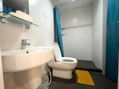 a bathroom with a white toilet and a sink at KL Tower Studio Near Greenbelt Makati in Manila