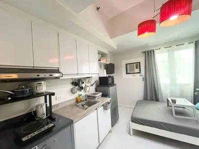 a kitchen with white cabinets and a sink in a room at KL Tower Studio Near Greenbelt Makati in Manila