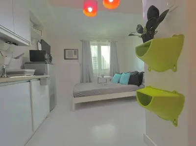 a white kitchen with a bed in a room at KL Tower Studio Near Greenbelt Makati in Manila
