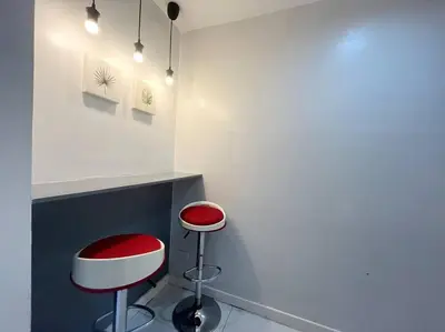 a room with two red and white stools next to a counter at KL Tower Studio Near Greenbelt Makati in Manila
