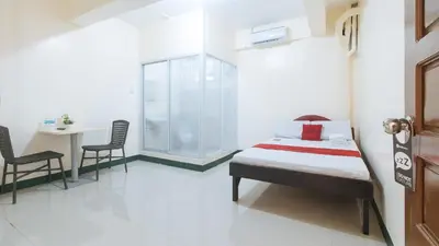 a bedroom with a bed and a table and chairs at RedDoorz @ Western Bicutan Transients Inn in Manila