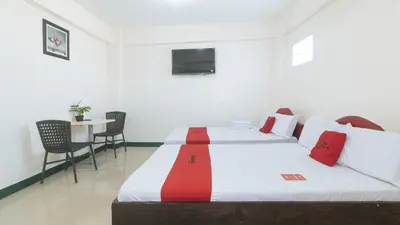 a hotel room with two beds and a table at RedDoorz @ Western Bicutan Transients Inn in Manila