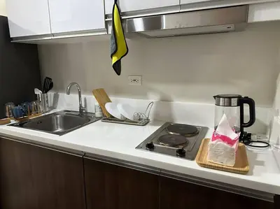 a kitchen counter with a stove with a coffee pot on it at My Hideaway@Air in Manila