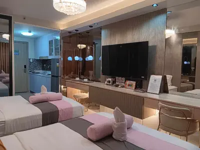 a hotel room with two beds and a television at New York Suite - by GUEST RESERVATION'S MANILA in Manila