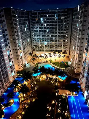 an aerial view of a large building at night at New York Suite - by GUEST RESERVATION'S MANILA in Manila