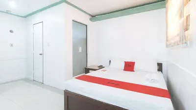 a bedroom with a bed with a red box on it at RedDoorz @ Moss Hotel Dasmarinas in Cavite