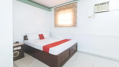 a small bedroom with a bed and a window at RedDoorz @ Moss Hotel Dasmarinas in Cavite