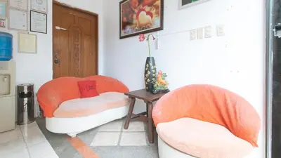two orange chairs in a room with a table at RedDoorz @ Moss Hotel Dasmarinas in Cavite