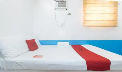 a bed in a room with a red white and blue at RedDoorz @ Moss Hotel Dasmarinas in Cavite
