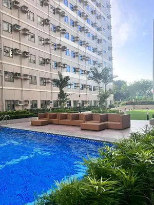 a hotel with a pool in front of a building at SMDC Green 2 Staycation, The Traditional & Modern Fusion Condo in Pasong Bayog