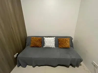 a couch with two pillows on it in a room at Fame Residences Pool View near MRT, Shaw, Megamall & Ortigas 1026 in Manila
