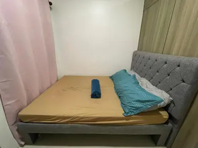 a bed in a small room with a blue pillow on it at Fame Residences Pool View near MRT, Shaw, Megamall & Ortigas 1026 in Manila