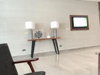 a waiting room with two lamps and a chair at Free Wi-Fi Luxurious Haven by the Bay - 2BR Near MOA PICC CCP in Manila