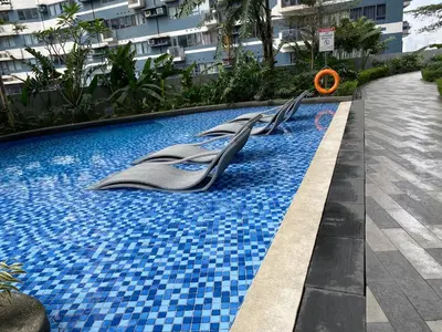 a swimming pool with escalators on the side of a building at Laugh and Lounge 2 Bedroom Luxury Condo Air residence Makati in Manila