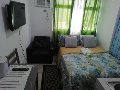 a bedroom with a bed and a chair and a desk at pierecondotel in Manila
