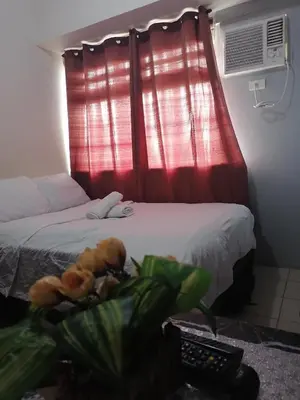 a bedroom with a bed with a red curtain at pierecondotel in Manila