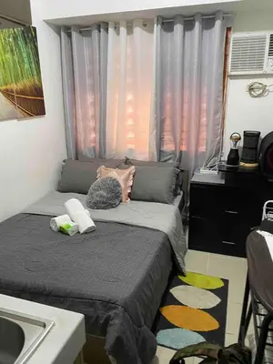 a small bedroom with a bed and a sink at pierecondotel in Manila