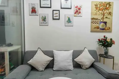 a living room with a gray couch and pictures on the wall at Azure skyview 1BR netflix karaoke ps3 Airport in Manila