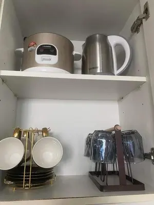 a kitchen shelf with utensils and a pot and pans at Azure skyview 1BR netflix karaoke ps3 Airport in Manila