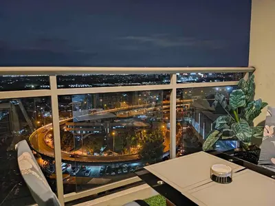 a view of a city at night from a balcony at Azure skyview 1BR netflix karaoke ps3 Airport in Manila