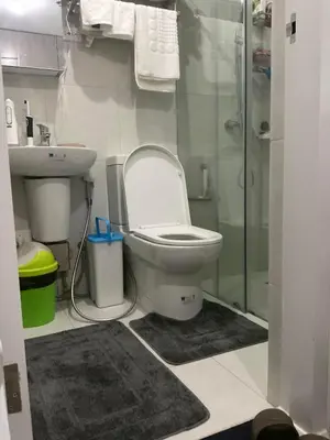 a bathroom with a toilet and a sink and a shower at Cookies Nest at 100West Makati in Manila