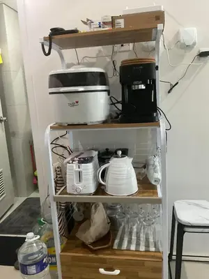 a shelf filled with dishes and appliances in a kitchen at Cookies Nest at 100West Makati in Manila