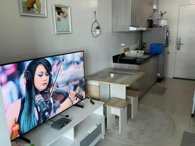 a television with a picture of a woman playing a violin at Cookies Nest at 100West Makati in Manila