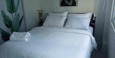 a white bed with white sheets and pillows at Cookies Nest at 100West Makati in Manila