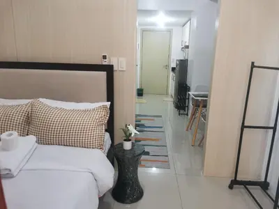 a bedroom with a bed and a hallway with a table at Condo UNIT-SM JAZZ RESIDENCES in Manila