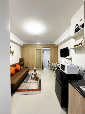 a kitchen and a living room with a couch at Shore Residences Tower C, Pasay near SM MOA, please text or call us ASAP once booked for the guest authorization form in Manila