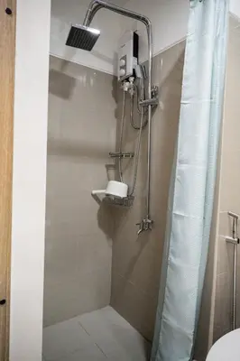 a bathroom with a shower with a sink and a toilet at Shore Residences Tower C, Pasay near SM MOA, please text or call us ASAP once booked for the guest authorization form in Manila