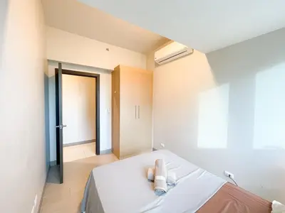 a bedroom with a bed with two towels on it at BGC 3BR Uptown Parksuites with bathtub 16 in Manila