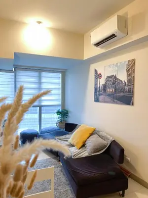 a living room with a bed and a window at BGC 3BR Uptown Parksuites with bathtub 16 in Manila