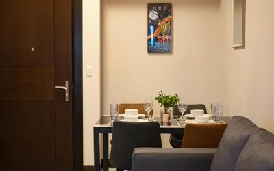 a dining room with a table with chairs and a table and a painting at BGC 2BR Uptown Parksuites with PS4 43 in Manila