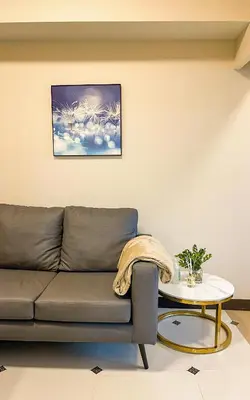 a living room with a couch and a table at BGC 2BR Uptown Parksuites with PS4 43 in Manila