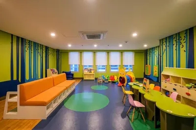 a childrens room with a couch and tables and chairs at BGC 2BR Uptown Parksuites with PS4 43 in Manila