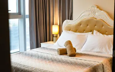 a bed with a teddy bear sitting on top of it at BGC 2BR Uptown Parksuites with PS4 43 in Manila