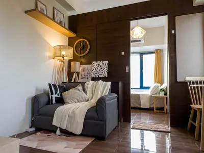 a living room with a blue couch and a bed at GemstoneBR II@SMDC Air Residences in Manila