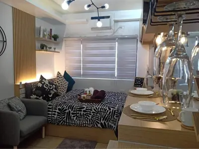 a living room with a bed and a table and a couch at ALABANG STUDIO unit w/ high speed Fiber WIFI in Manila