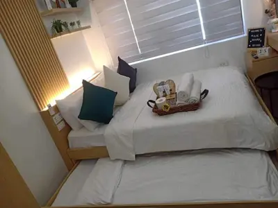 a small bedroom with a bed with a basket on it at ALABANG STUDIO unit w/ high speed Fiber WIFI in Manila