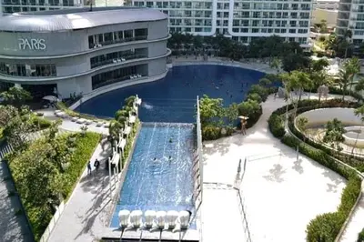 a large swimming pool in front of a building at Azure 1BR citylights with netlfix near airport in Manila