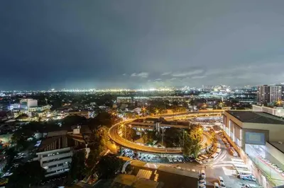 a city lit up at night with cars on a road at Azure 1BR citylights with netlfix near airport in Manila
