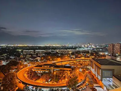 a city lit up at night with a train at Azure 1BR citylights with netlfix near airport in Manila