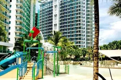 a playground in front of a large building at Azure 1BR citylights with netlfix near airport in Manila