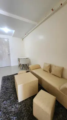a living room with two beds and a table at URBAN DECA Homes SM EAST Pasig in Manila