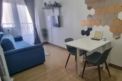 a living room with a table and a blue couch at Bicutan Urban Haven in Manila