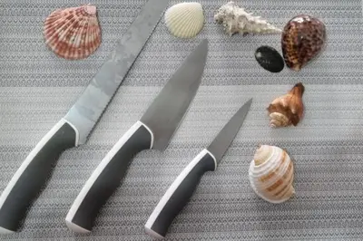 two knives and some shells on a table at Bicutan Urban Haven in Manila